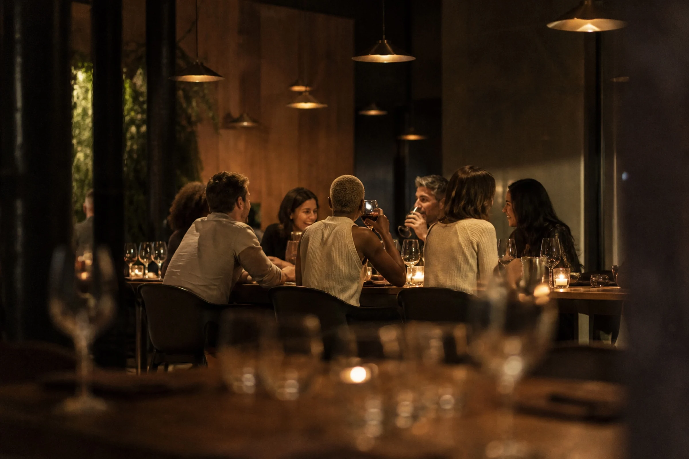 Guests together at a long table in a warmly lit dining room